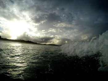 Scenic view of sea against cloudy sky during sunset