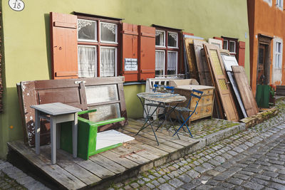 Empty chairs and tables against building