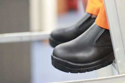 Workers climb the stairs wearing safety shoes made of leather and soles made of rubber. 
