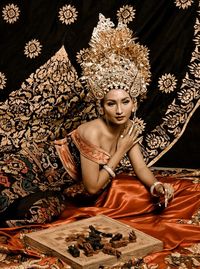 Portrait of young woman sitting on bed