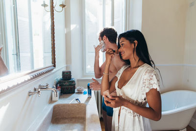 Friends standing in bathroom at home