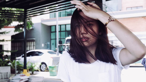 Close-up of woman with tousled hair standing in city