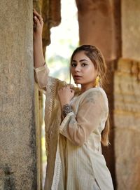 Portrait of young woman standing in building