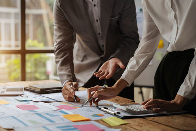 Midsection of business people working at office