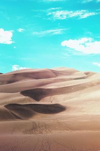 Sand dunes in desert against sky