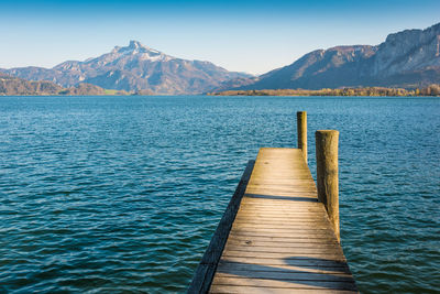 Wooden pier in lake against mountains