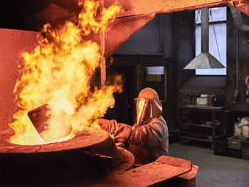 Industry, worker at furnace during melting copper, wearing a fire proximity suit