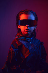 Portrait cyberpunk boy child in vr glasses in blue and red tones. game, virtual reality
