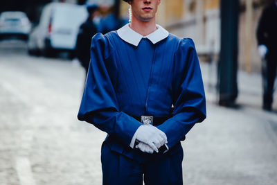 Midsection of man standing against blurred background