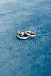 Close-up of wedding rings on blue background