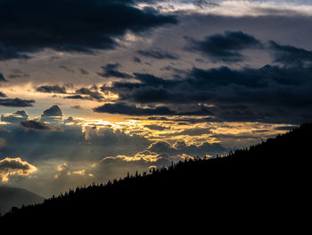 Scenic view of silhouette mountains against dramatic sky