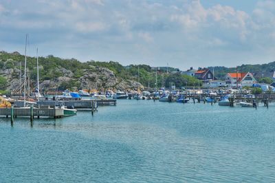 Boats moored at harbor against sky