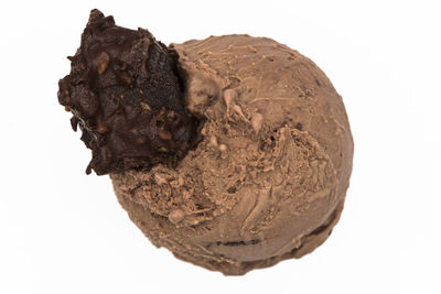 Close-up of chocolate cake on rock against white background