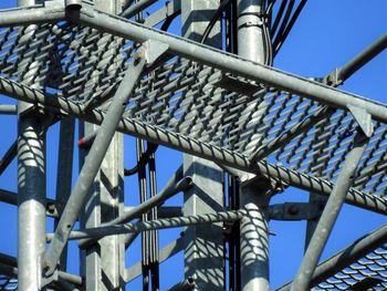 Low angle view of metallic structure against blue sky