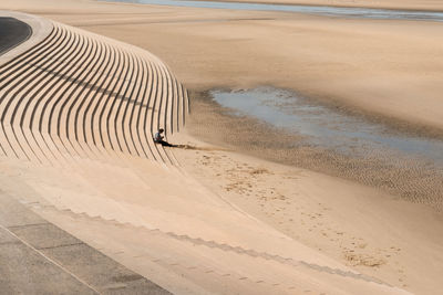 High angle view of man sitting on steps at beach