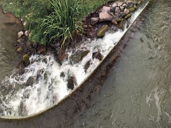 High angle view of stream flowing through rocks