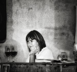 Portrait of a serious young woman drinking glass on table