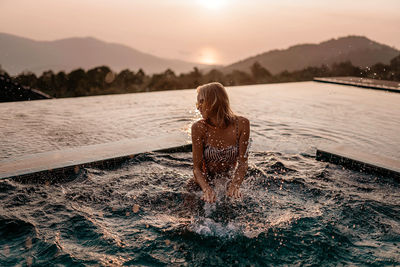 Girl in the pool at sunset