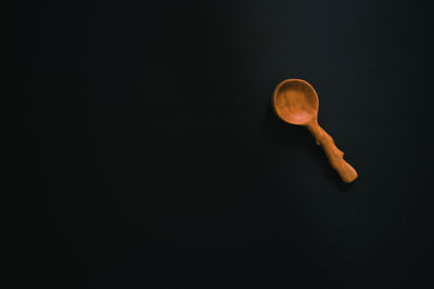 Close-up of wooden spoon against black background