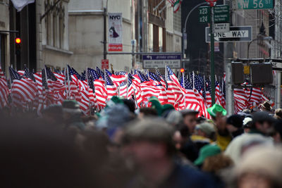Crowd with american flags by buildings in city
