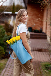 Portrait of a happy female florist with a bouquet of yellow tulips. women's day, valentine's day