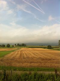 Scenic view of field against cloudy sky