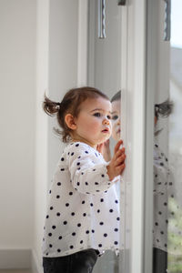 Little girl with ponytails looks out the window. new home rental.