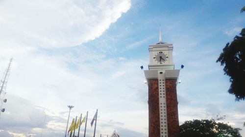 Low angle view of clock against sky