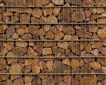 Full frame shot of rocks behind metal fence