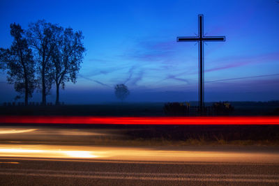 Light trails on street against sky at night