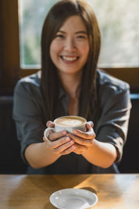 Portrait of a smiling young woman with coffee