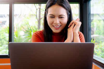 Asia woman smile and looking at laptop. happy woman working at o