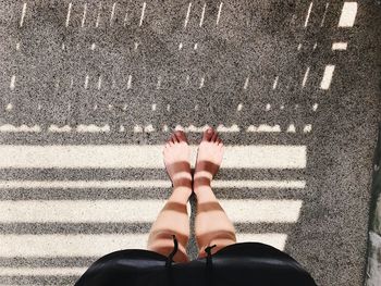 Low section of woman standing on road