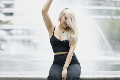 Young woman looking away while standing in city