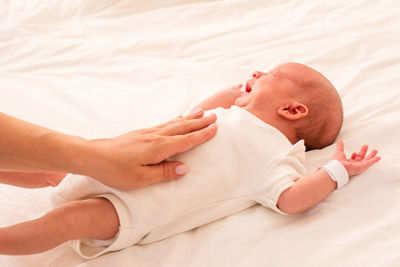 Cropped hand of mother taking care of baby