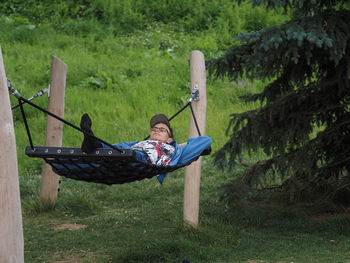 A young man is lying on a hammock in a park or garden outdoors. high quality photo