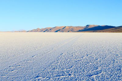 Scenic view of arid landscape against clear blue sky