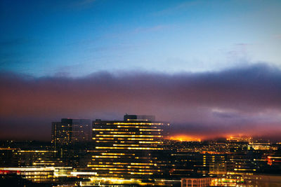 Illuminated cityscape against sky at night