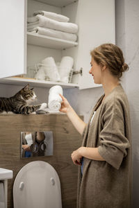 Side view of woman standing at home