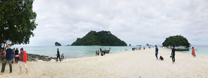 People enjoying at beach against clear sky