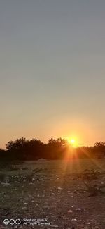 Scenic view of field against clear sky during sunset