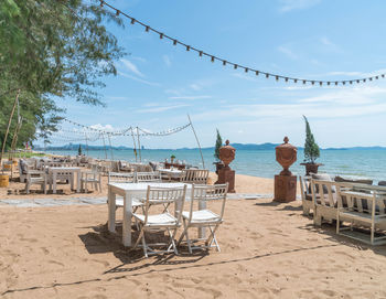 Chairs on beach against sky