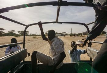 MEN SITTING ON ROAD