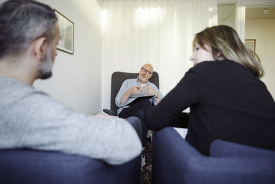 Male therapist explaining couple during therapy session at community center