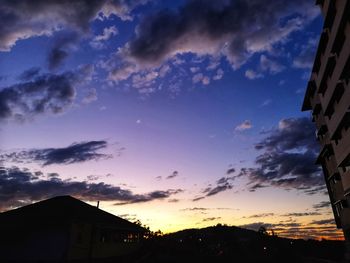 Low angle view of silhouette buildings against sky at sunset