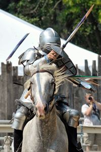 Man wearing warrior costume while riding horse