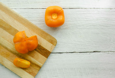 Close-up of persimmon on cutting board over table