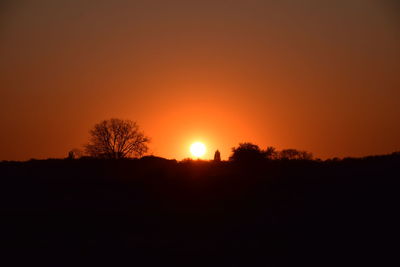 Silhouette trees against sky during sunset