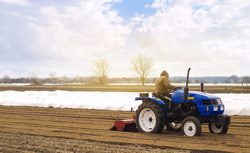 Farmer on a tractor with milling machine loosens, grinds and mixes soil. loosening the surface