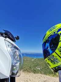Close-up of sunglasses on beach against clear blue sky